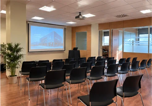 Recreación de una sala preparada con sillas y proyector